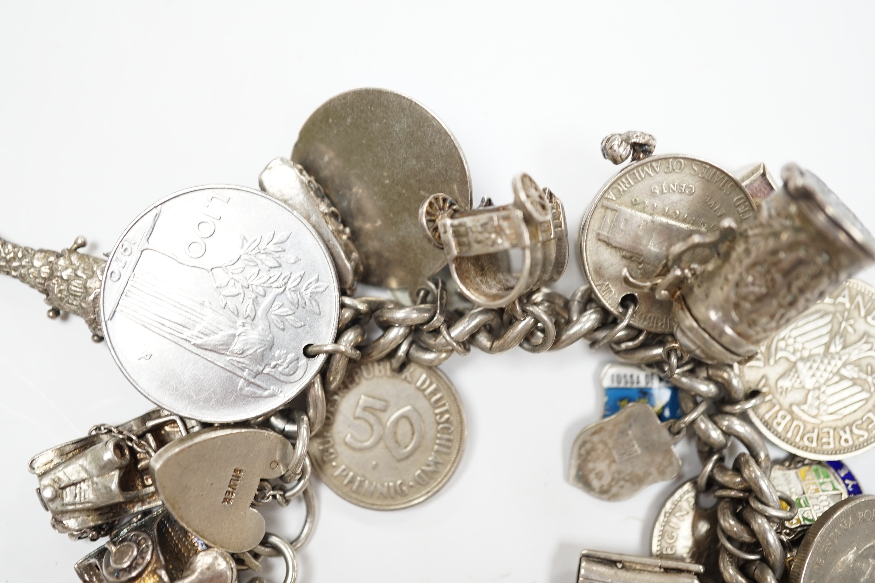 A silver charm bracelet, hung with assorted mainly white metal charms including tankard and Knight's helmet, two 'melted' ingots and a silver medallion.